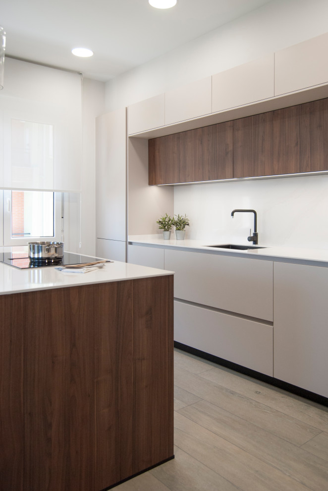 Example of a large single-wall open concept kitchen design in Bilbao with an undermount sink, flat-panel cabinets, dark wood cabinets, quartz countertops, white backsplash, quartz backsplash, black appliances, an island and white countertops