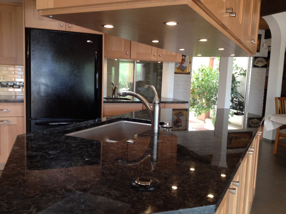 Open concept kitchen - large transitional l-shaped open concept kitchen idea in Phoenix with an undermount sink, shaker cabinets, light wood cabinets, granite countertops, black appliances and an island