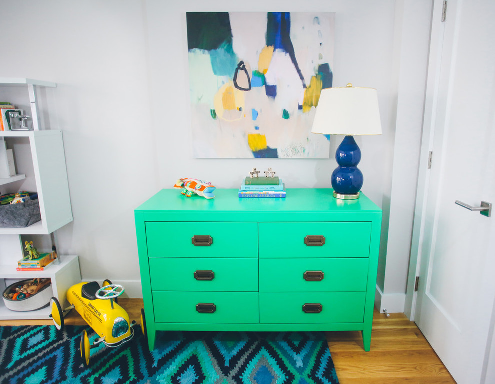 Mid-sized modern kids' room in New York with white walls and light hardwood floors for boys.