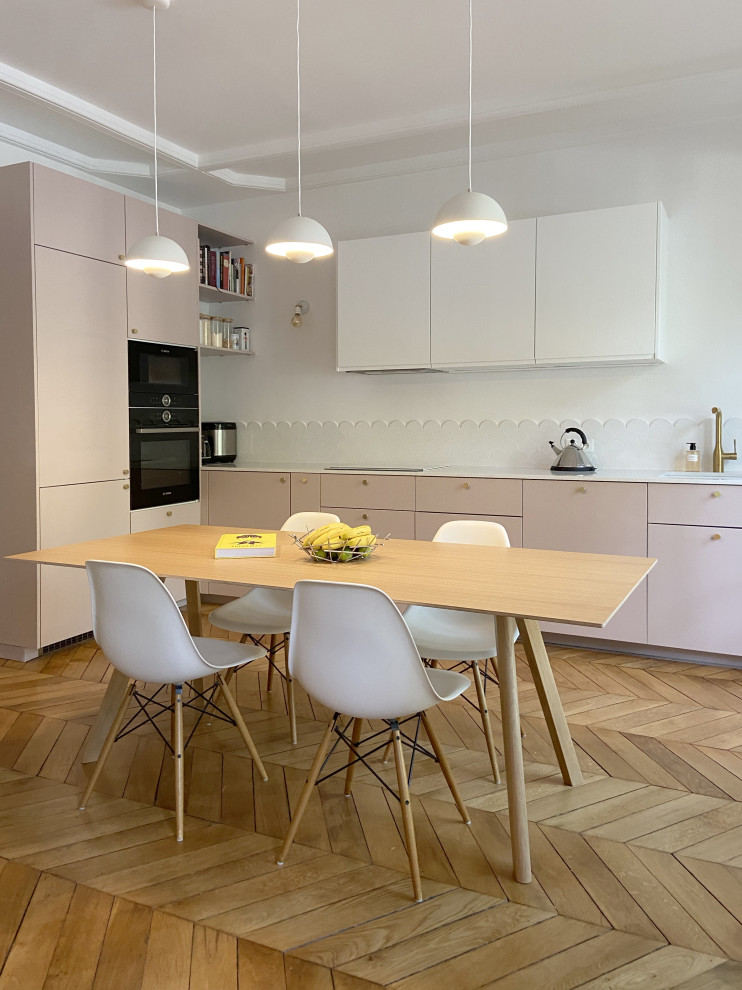 Photo of a large modern l-shaped eat-in kitchen in Paris with pink cabinets, quartzite benchtops, white splashback, ceramic splashback, no island and white benchtop.