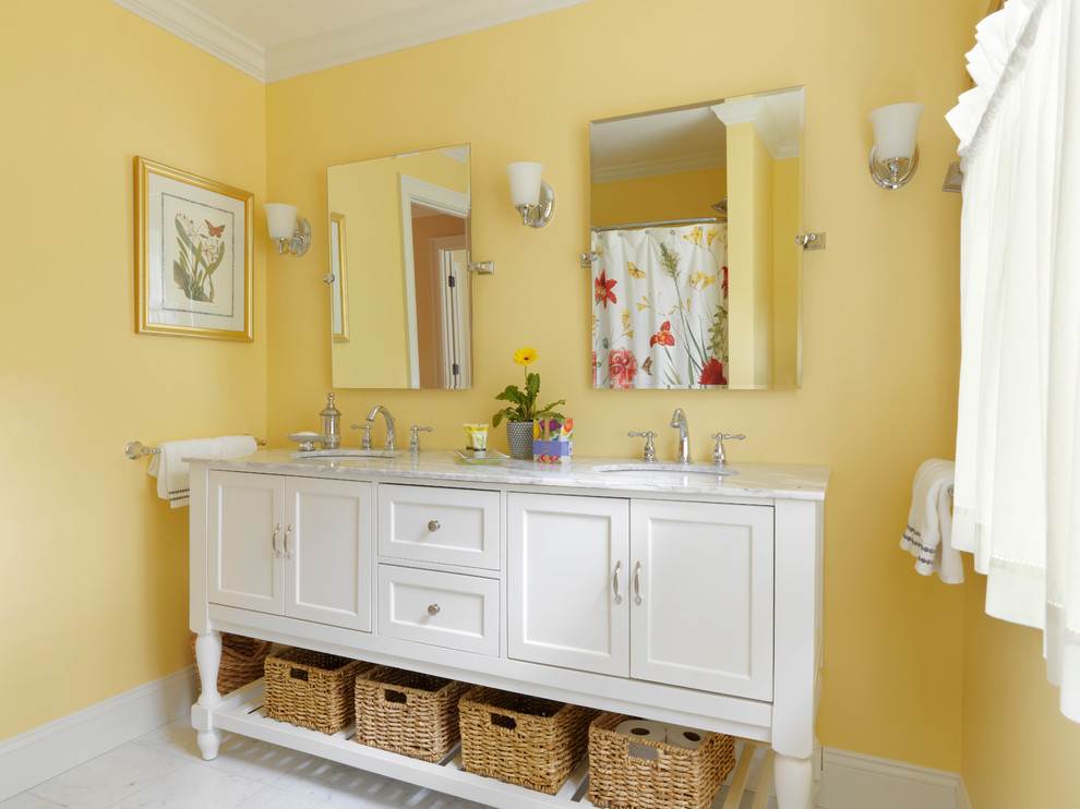Inspiration for a country bathroom in Burlington with a console sink, furniture-like cabinets, white cabinets, marble benchtops, an alcove tub, a shower/bathtub combo, a two-piece toilet, white tile, stone tile, yellow walls and marble floors.