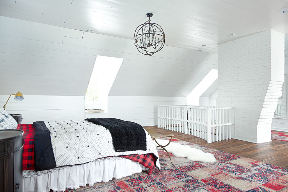 Design ideas for a large country loft-style bedroom in Dallas with white walls, medium hardwood floors and brown floor.