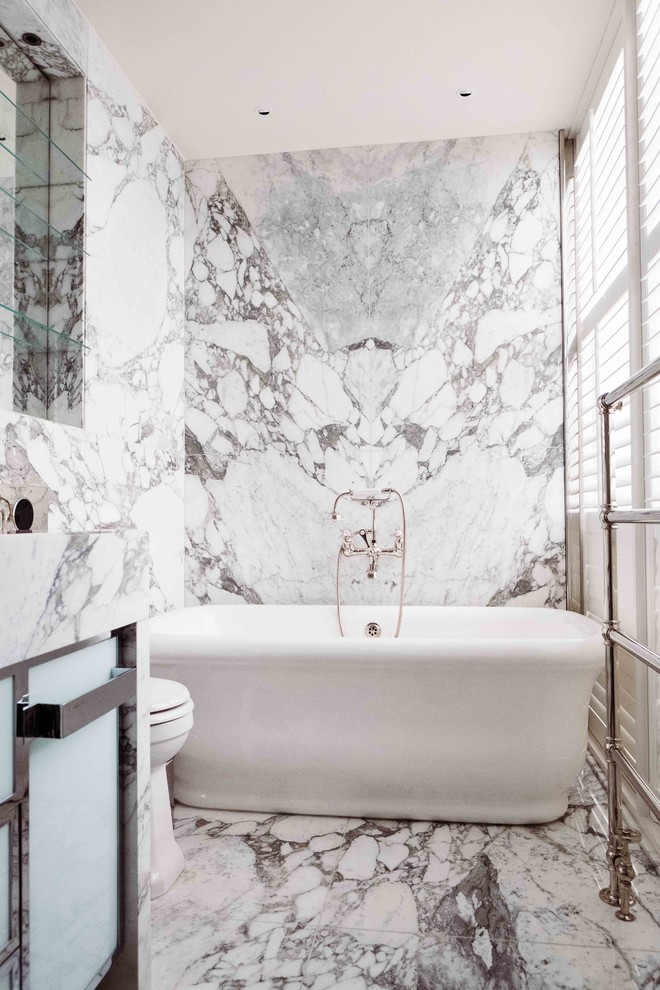 Contemporary 3/4 bathroom in London with glass-front cabinets, white cabinets, a freestanding tub, gray tile, white tile, marble, white walls, marble floors, marble benchtops, white floor and white benchtops.