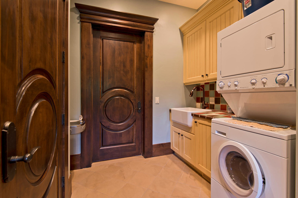Photo of a mediterranean laundry room in Salt Lake City with a farmhouse sink and beige floor.