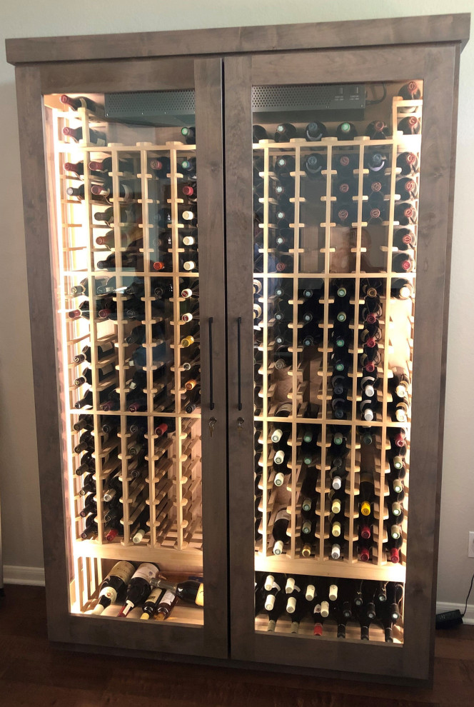 Design ideas for a mid-sized modern wine cellar in Raleigh with dark hardwood floors, storage racks and brown floor.