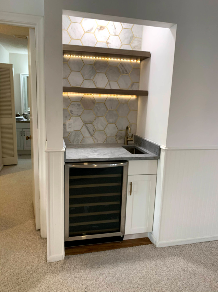 This is an example of a small modern single-wall wet bar in Miami with a submerged sink, shaker cabinets, white cabinets, marble worktops, white splashback, marble splashback, porcelain flooring, brown floors and grey worktops.