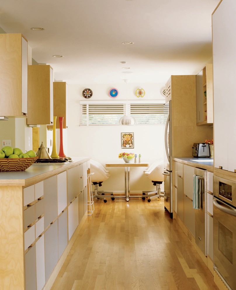Photo of an eclectic galley eat-in kitchen in Detroit with flat-panel cabinets, grey cabinets and stainless steel appliances.