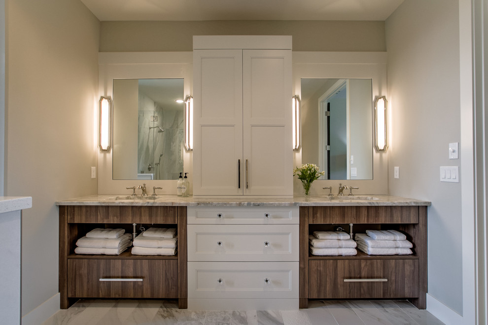 Large country master bathroom in Omaha with a freestanding tub, a two-piece toilet, porcelain tile, porcelain floors, an undermount sink, marble benchtops, white cabinets, a corner shower, white tile, white floor, a hinged shower door, recessed-panel cabinets and grey walls.