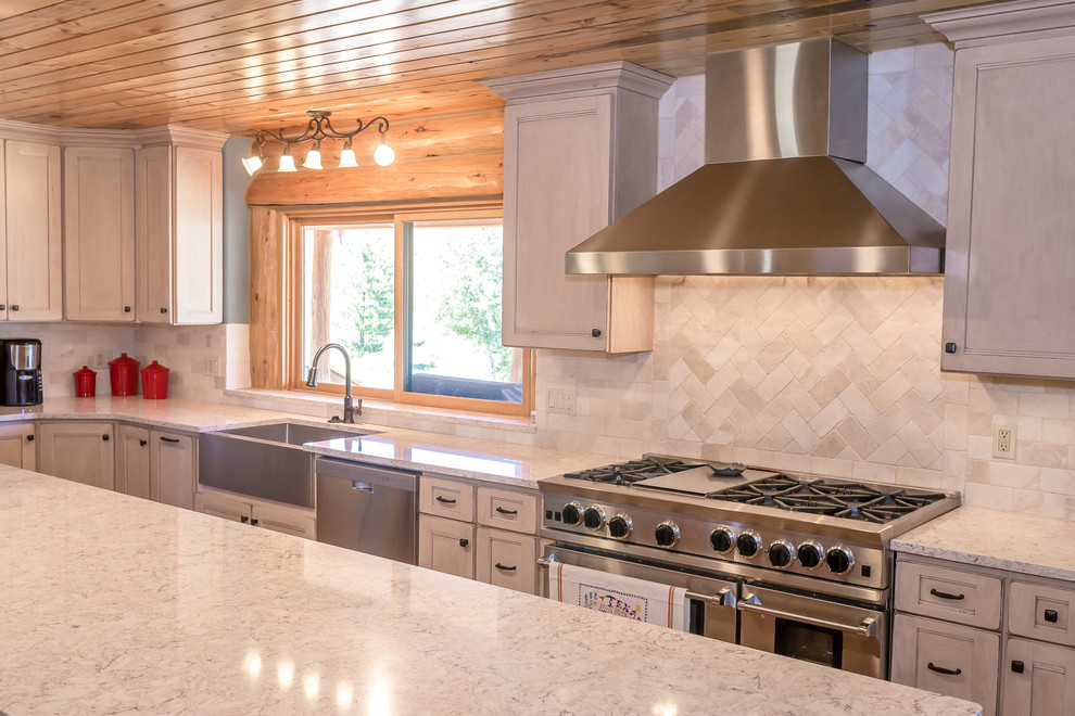 Mid-sized mountain style l-shaped beige floor enclosed kitchen photo in Denver with a farmhouse sink, medium tone wood cabinets, granite countertops, white backsplash, stainless steel appliances, an island and gray countertops
