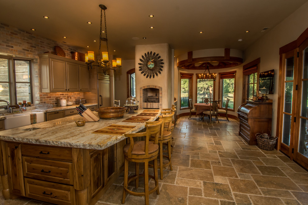 Photo of an expansive country eat-in kitchen in Denver with a farmhouse sink, distressed cabinets, granite benchtops, stainless steel appliances, travertine floors, with island, louvered cabinets and stone tile splashback.