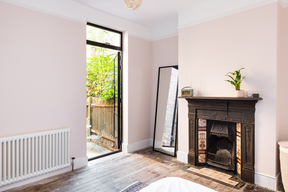 Photo of an urban bedroom in London with a standard fireplace.