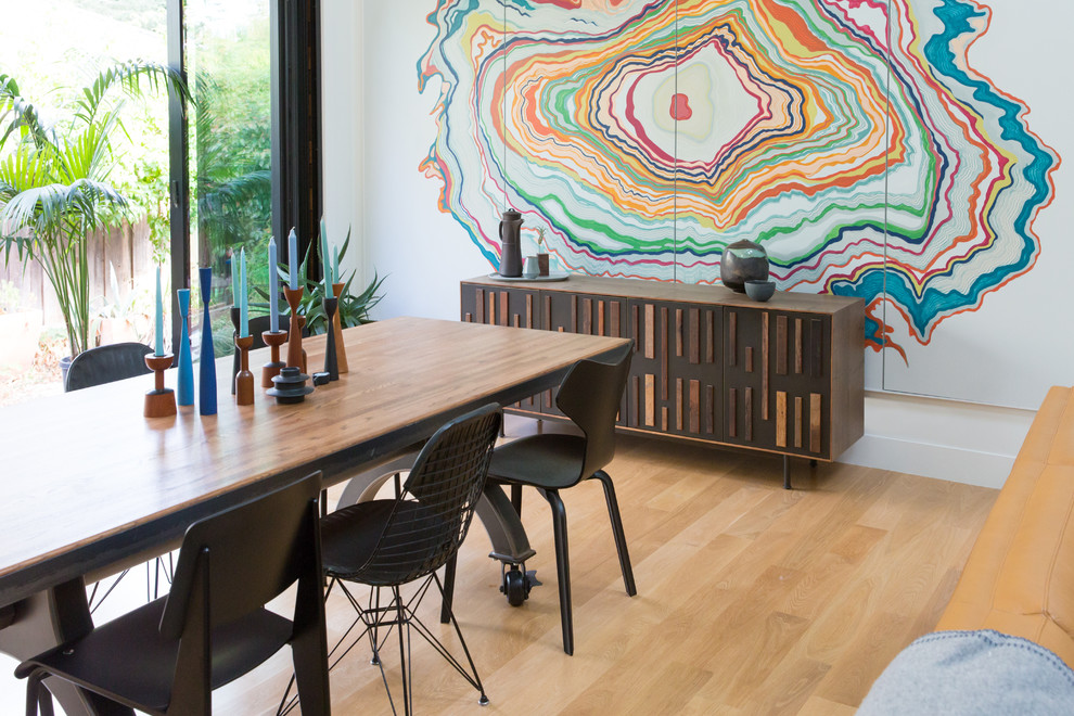 Midcentury dining room in San Francisco with multi-coloured walls and light hardwood floors.
