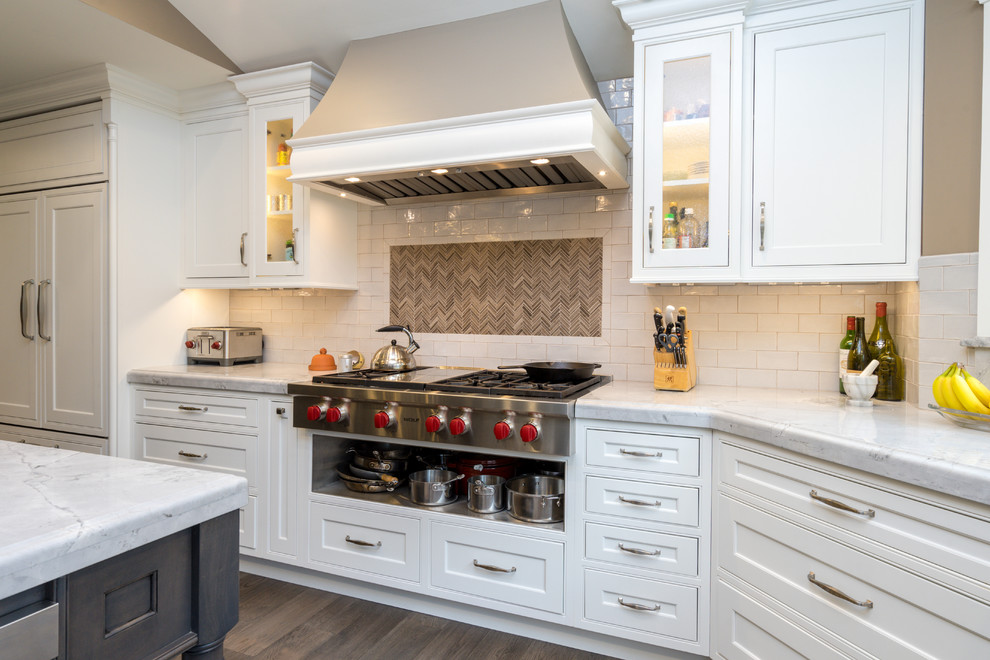 Large transitional l-shaped eat-in kitchen in Philadelphia with an undermount sink, beaded inset cabinets, white cabinets, granite benchtops, white splashback, subway tile splashback, stainless steel appliances, dark hardwood floors, with island, brown floor and white benchtop.