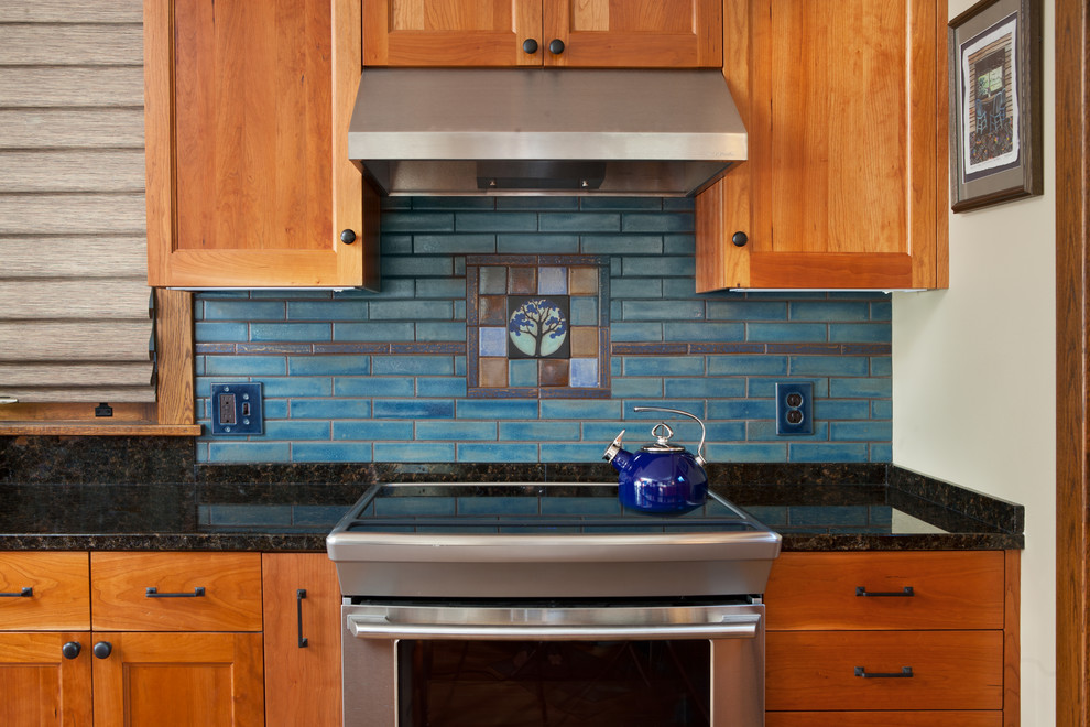 Inspiration for a small arts and crafts single-wall separate kitchen in Minneapolis with recessed-panel cabinets, medium wood cabinets, granite benchtops, blue splashback, ceramic splashback, stainless steel appliances and with island.