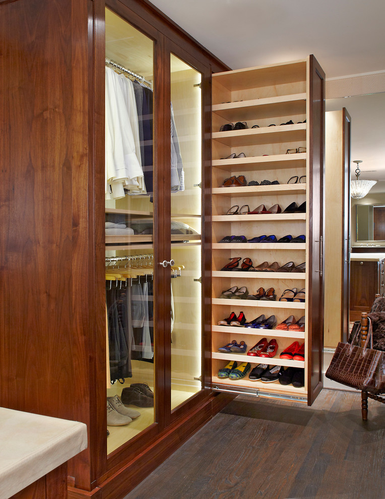 Photo of a traditional gender-neutral storage and wardrobe in Dallas with dark wood cabinets and dark hardwood floors.