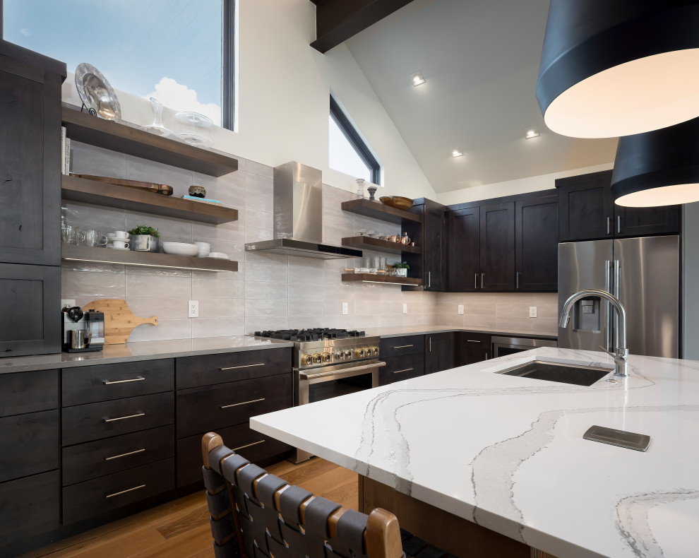 Photo of a medium sized contemporary l-shaped open plan kitchen in Denver with shaker cabinets, grey cabinets, white splashback, stainless steel appliances, light hardwood flooring, an island, white worktops and a timber clad ceiling.