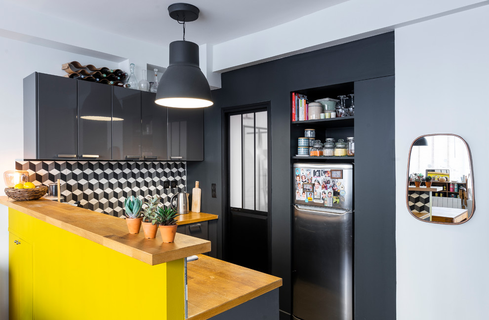 Inspiration for a small contemporary u-shaped eat-in kitchen in Paris with a single-bowl sink, flat-panel cabinets, grey cabinets, wood benchtops, cement tile splashback, cement tiles, black floor, multi-coloured splashback, stainless steel appliances, a peninsula and beige benchtop.