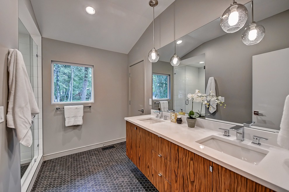 Design ideas for a large midcentury master bathroom in Charlotte with flat-panel cabinets, an alcove tub, an alcove shower, a two-piece toilet, gray tile, ceramic tile, grey walls, mosaic tile floors, an undermount sink, engineered quartz benchtops, black floor, a hinged shower door and grey benchtops.
