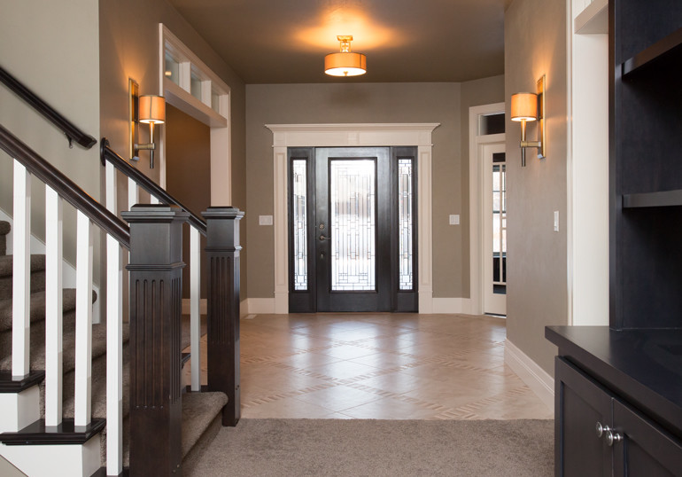 Large transitional vinyl floor and beige floor foyer photo with beige walls and a dark wood front door