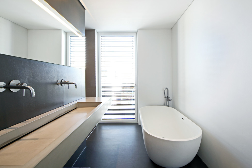Mid-sized contemporary bathroom in Stuttgart with a freestanding tub, white walls, concrete benchtops and a trough sink.
