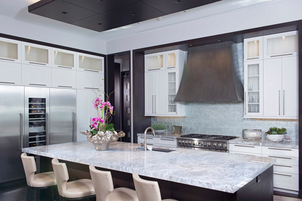 Kitchen - transitional kitchen idea in Orlando with an undermount sink, shaker cabinets, white cabinets, metallic backsplash, subway tile backsplash, stainless steel appliances and an island