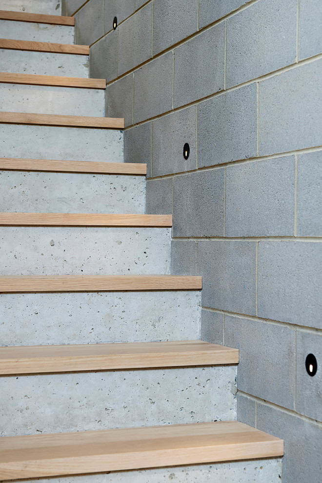 Photo of a modern wood straight staircase in Perth with concrete risers, metal railing and brick walls.