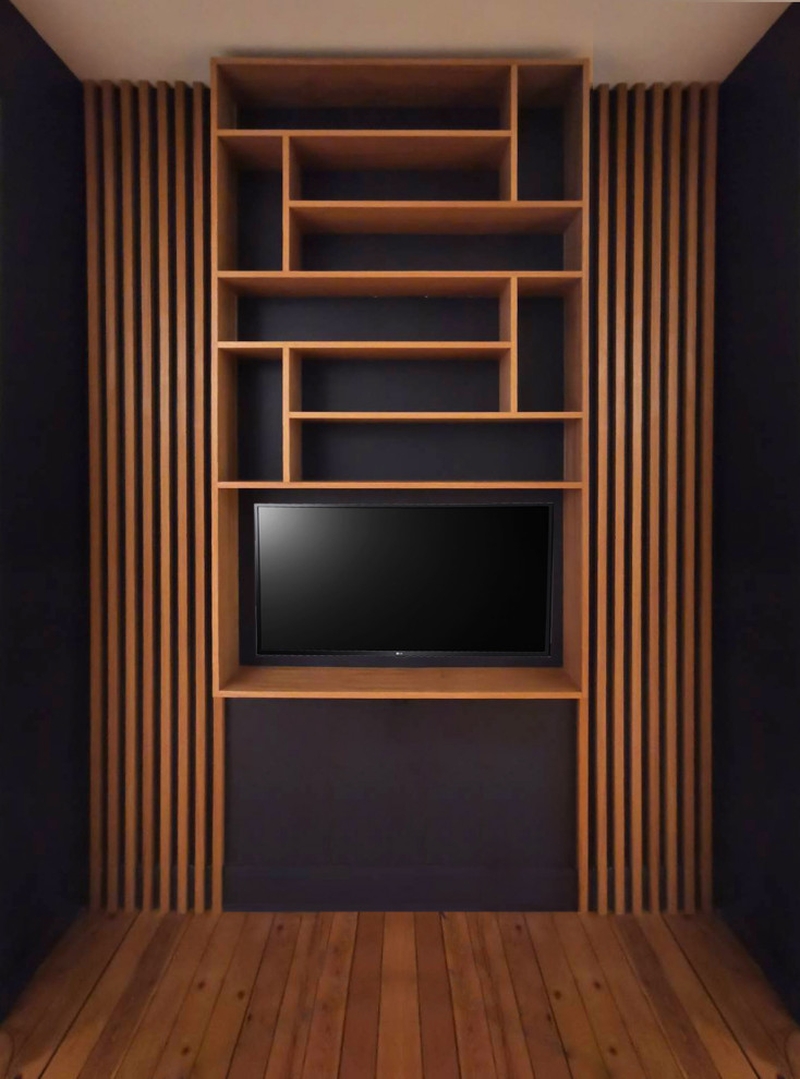 Exempel på ett mellanstort klassiskt vardagsrum, med ett bibliotek, svarta väggar, mellanmörkt trägolv, en väggmonterad TV och brunt golv