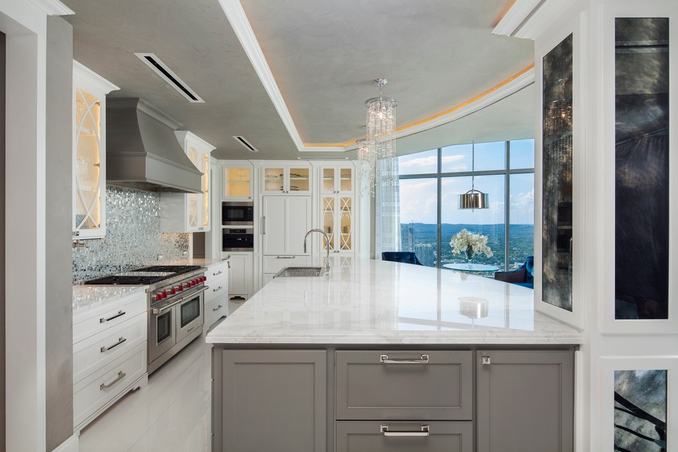 This is an example of a transitional eat-in kitchen in Austin with glass-front cabinets, white cabinets, metallic splashback, metal splashback and stainless steel appliances.