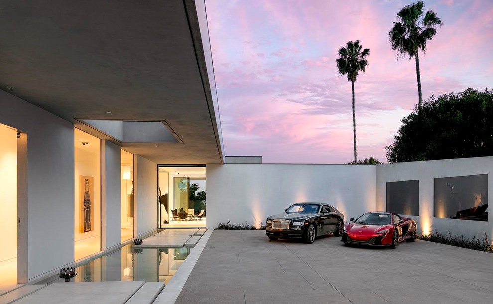 This is an example of an expansive contemporary front door in Los Angeles with white walls, concrete floors and a pivot front door.