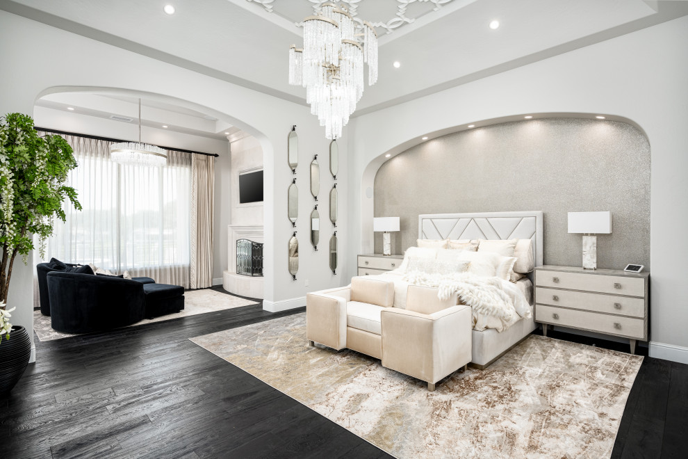 Photo of an expansive modern master bedroom in Phoenix with white walls, dark hardwood floors, a standard fireplace, a concrete fireplace surround, brown floor, coffered and panelled walls.