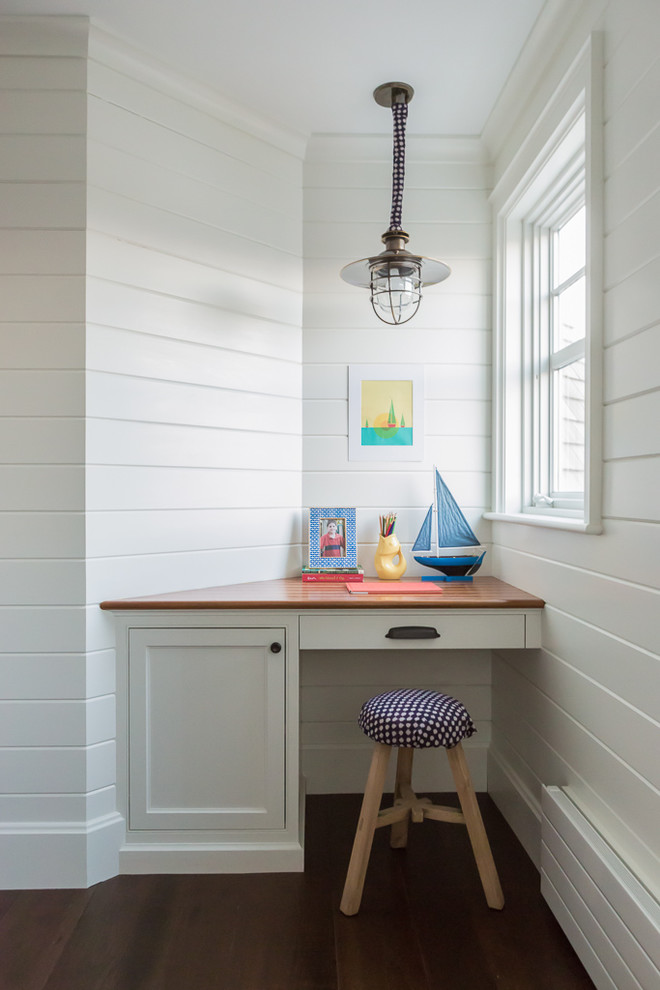 Photo of a small beach style gender-neutral kids' study room in Portland Maine with white walls and dark hardwood floors.