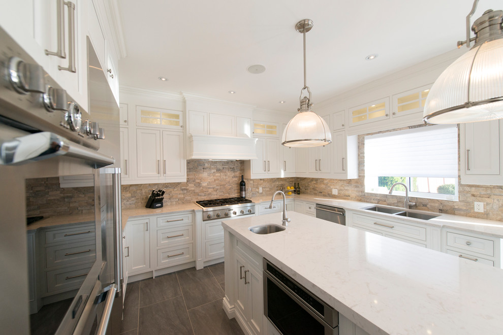 Inspiration for a transitional porcelain tile and gray floor eat-in kitchen remodel in Toronto with an undermount sink, beaded inset cabinets, white cabinets, quartzite countertops, brick backsplash, stainless steel appliances, an island and white countertops