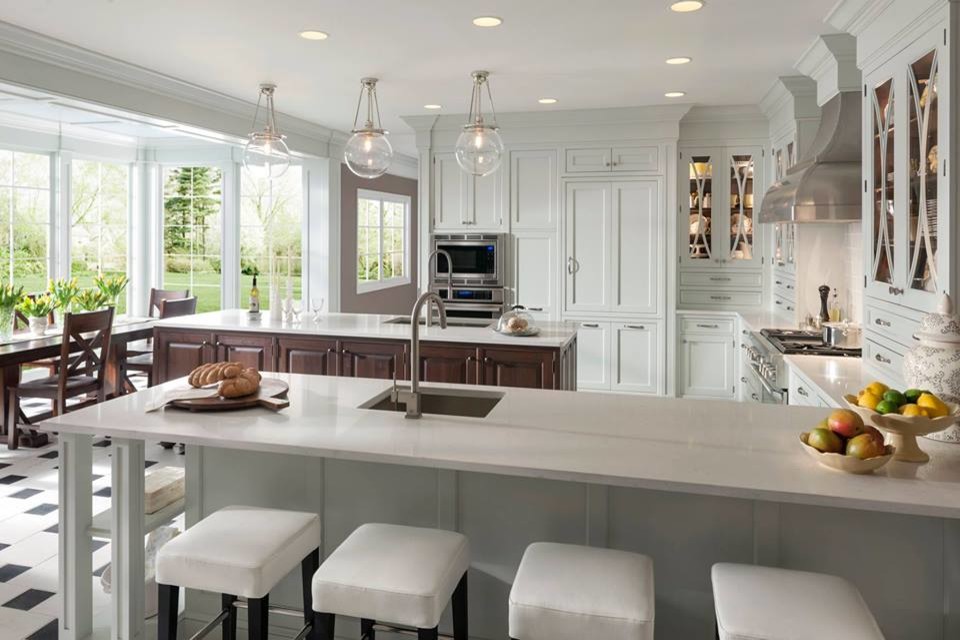 Large transitional u-shaped porcelain tile eat-in kitchen photo in Houston with recessed-panel cabinets, white cabinets, solid surface countertops, white backsplash, mosaic tile backsplash, a drop-in sink, stainless steel appliances and two islands