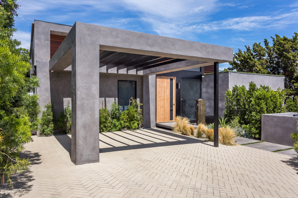 Idée de décoration pour une grande façade de maison grise design en béton à un étage avec un toit plat et un toit végétal.