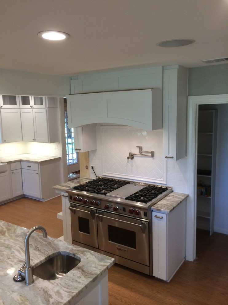 Inspiration for a kitchen in Austin with shaker cabinets, white cabinets, granite benchtops, white splashback, ceramic splashback and stainless steel appliances.