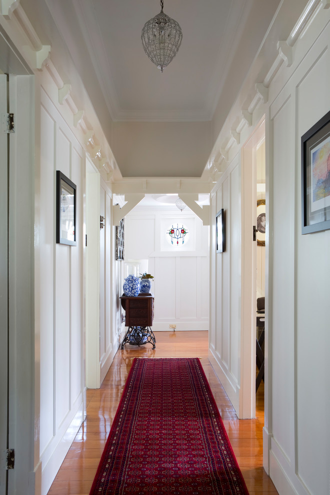 Inspiration for a beach style hallway in Brisbane with white walls, medium hardwood floors and brown floor.
