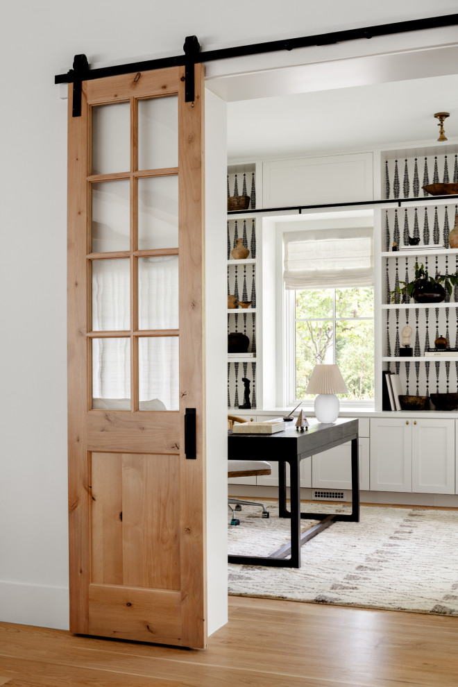 Large farmhouse freestanding desk light wood floor, beige floor and wallpaper home office photo in DC Metro with multicolored walls