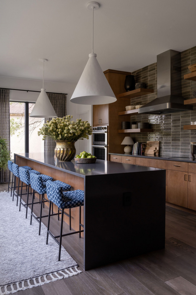 Design ideas for a mid-sized transitional galley eat-in kitchen in Austin with flat-panel cabinets, medium wood cabinets, quartz benchtops, brown splashback, ceramic splashback, stainless steel appliances, with island, brown floor, grey benchtop and dark hardwood floors.