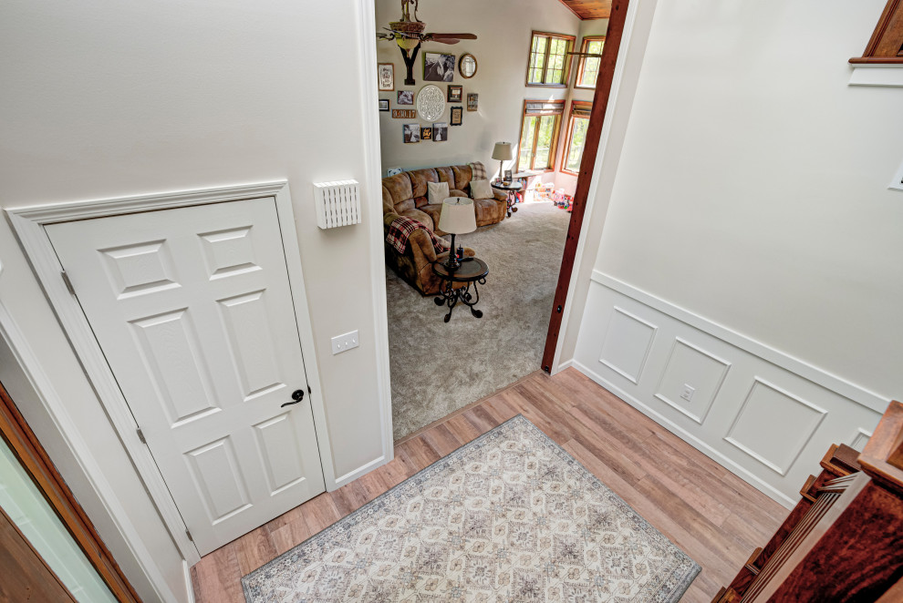 This is an example of a mid-sized traditional front door in Indianapolis with a single front door, a medium wood front door, medium hardwood floors, beige floor, multi-coloured walls and decorative wall panelling.