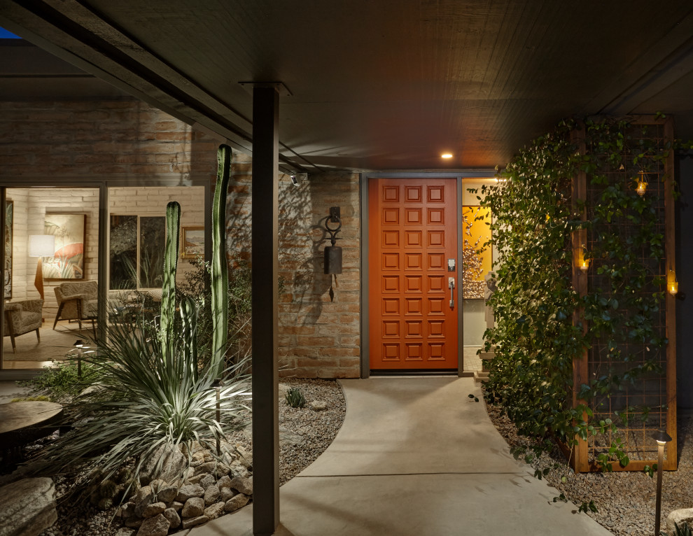 Kleine Mid-Century Haustür mit grauer Wandfarbe, Betonboden, oranger Haustür, grauem Boden, Holzdielendecke und Ziegelwänden in Phoenix