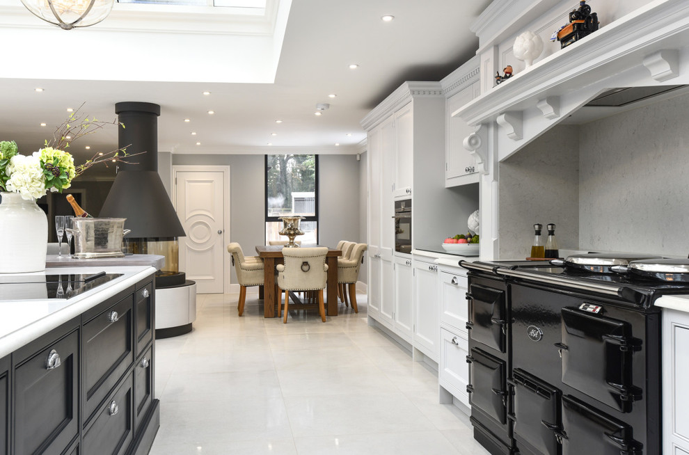 Design ideas for a large l-shaped eat-in kitchen in Berkshire with a drop-in sink, shaker cabinets, grey cabinets, granite benchtops, grey splashback, mirror splashback, panelled appliances, with island and white benchtop.