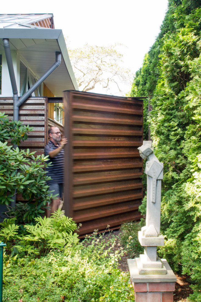 Esempio di un piccolo giardino formale minimalista esposto a mezz'ombra dietro casa in estate con cancello, pacciame e recinzione in metallo
