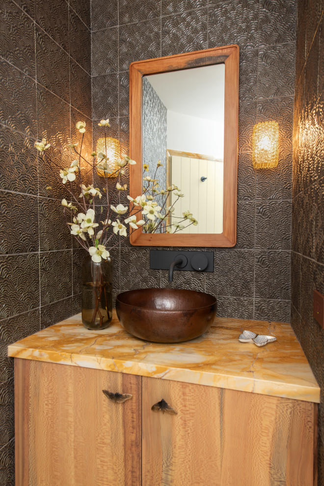 Photo of a mid-sized contemporary bathroom in Los Angeles with flat-panel cabinets, light wood cabinets, an alcove shower, a wall-mount toilet, orange tile, metal tile, white walls, marble floors, a vessel sink, marble benchtops, yellow floor, a hinged shower door, yellow benchtops, a single vanity and a floating vanity.