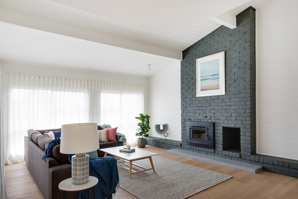 Design ideas for a large contemporary open concept living room in Sydney with white walls, limestone floors, a standard fireplace and a brick fireplace surround.