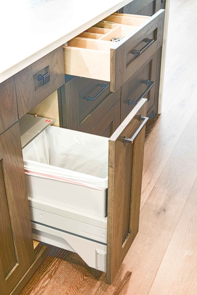 Mid-sized transitional u-shaped medium tone wood floor and brown floor home design photo in Calgary with an undermount sink, flat-panel cabinets, white cabinets, marble countertops, gray backsplash, ceramic backsplash, paneled appliances and an island