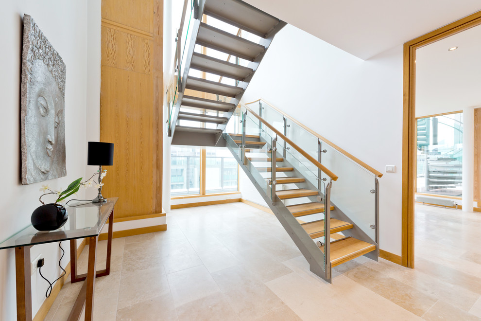 Inspiration for a contemporary wood u-shaped staircase in Dublin with open risers and glass railing.