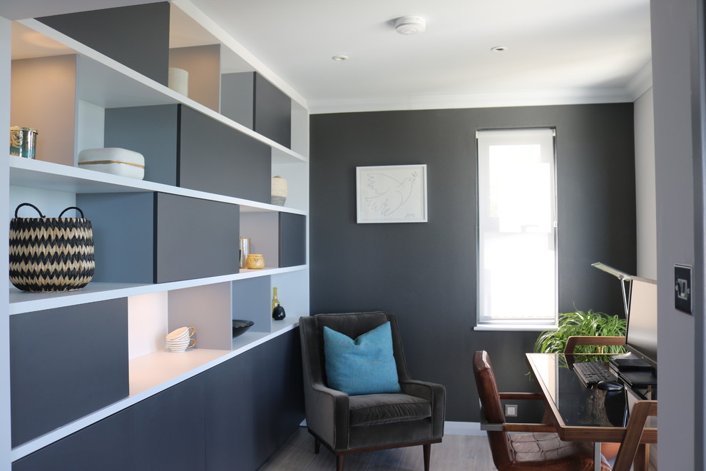 This is an example of a small contemporary study room in Devon with grey walls, light hardwood floors and a freestanding desk.