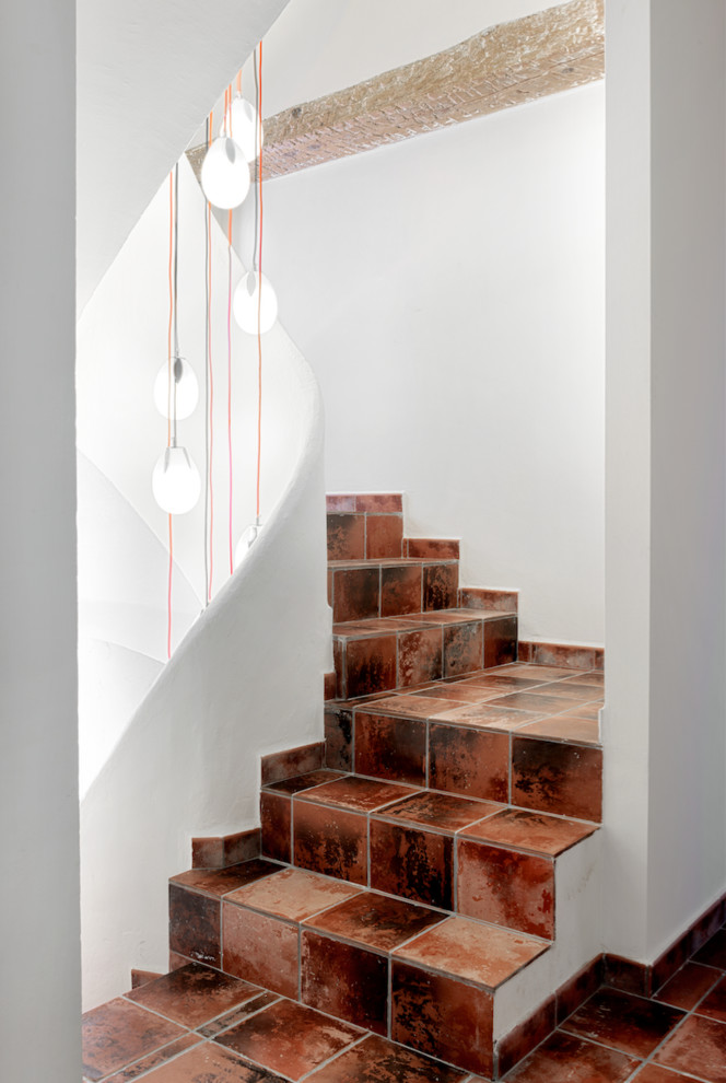 Inspiration for a mediterranean tile l-shaped staircase in Other with tile risers.