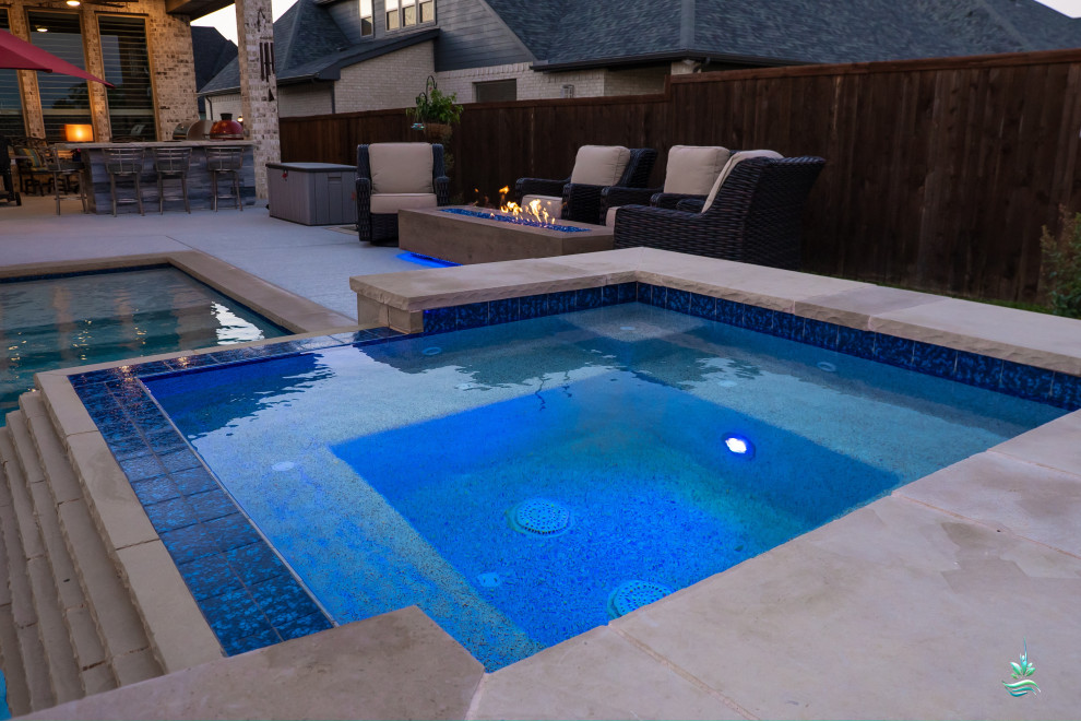 Immagine di una grande piscina naturale moderna personalizzata dietro casa con una vasca idromassaggio e lastre di cemento