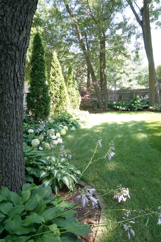 This is an example of a mid-sized transitional backyard concrete paver landscaping in Cedar Rapids with a fire pit and a gazebo.